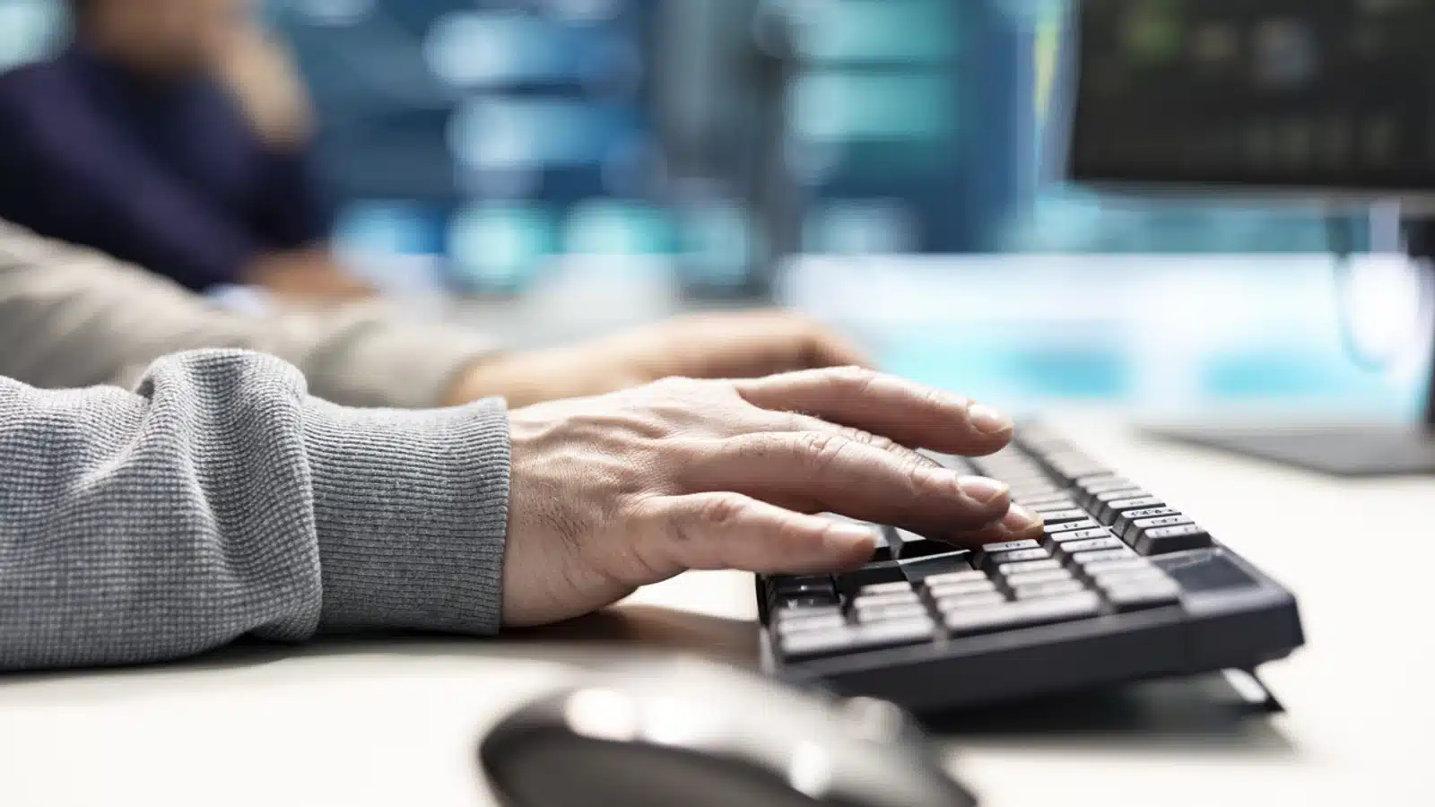 Assistance et Solutions Informatiques - homme travaillant sur un ordinateur en utilisant le clavier